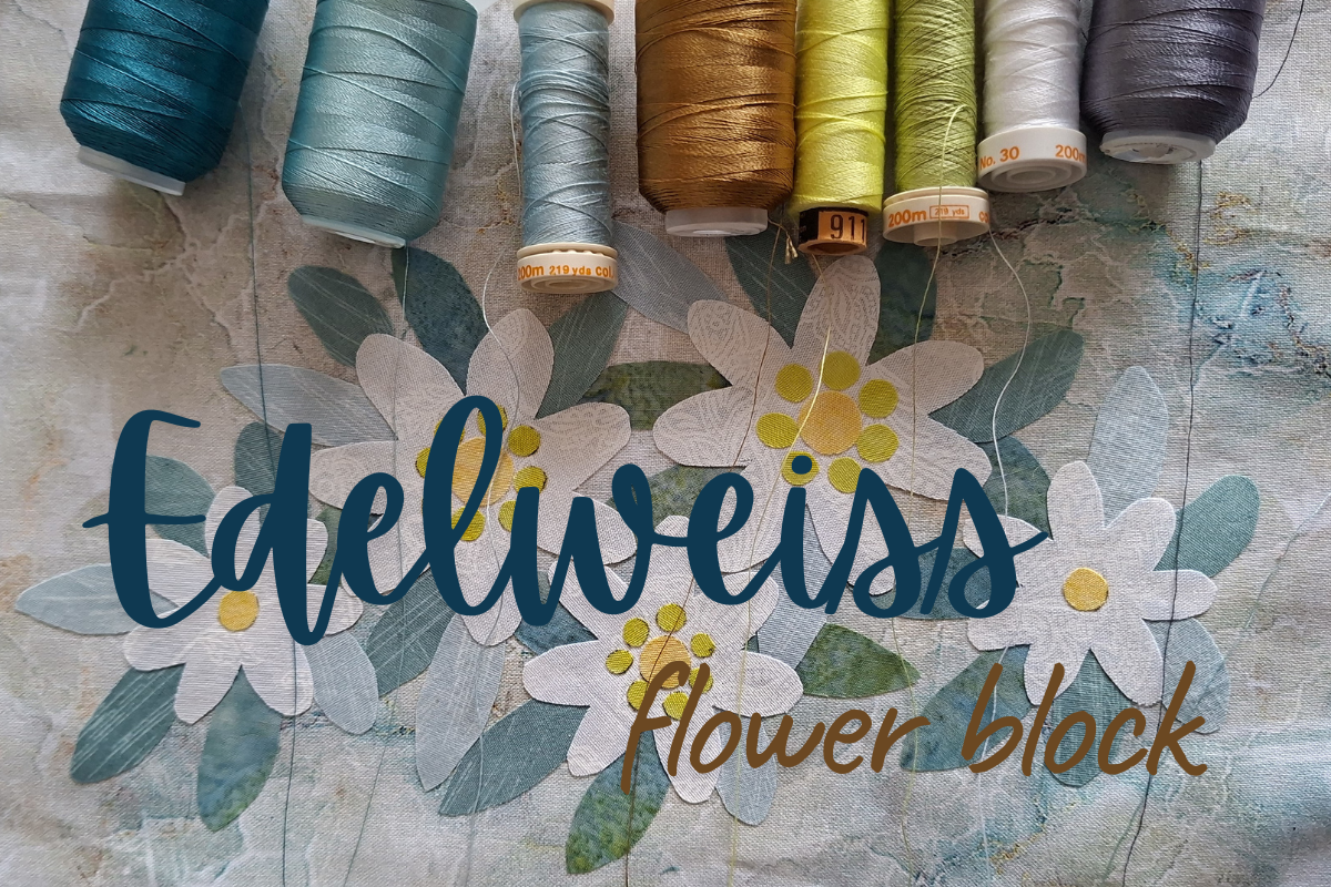A fabric flower block design featuring layered white daisies with yellow centers and blue-green leaves, overlaid with the text 'Edeliweiss' in dark blue script and 'flower block' in brown script. Seven spools of thread in various colors are lined up along the top edge against a textured, distressed background.