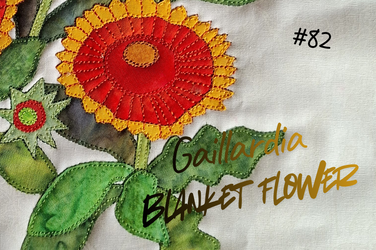 Embroidered flower design with red center and yellow petals on a textured fabric background.