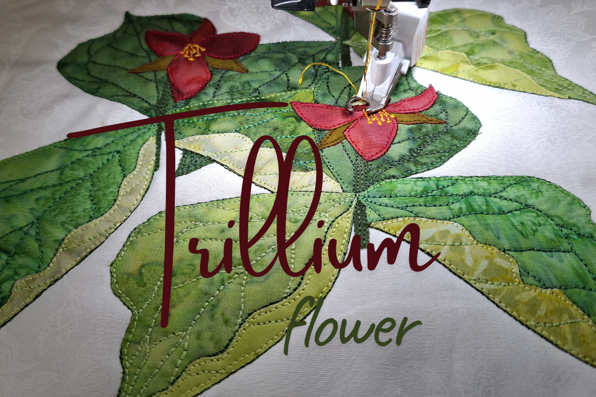 A close-up of a sewing machine stitching a quilted fabric design featuring green trillium leaves and red trillium flowers on a white fabric background, with the words 'Trillium flower' overlaid across the center.